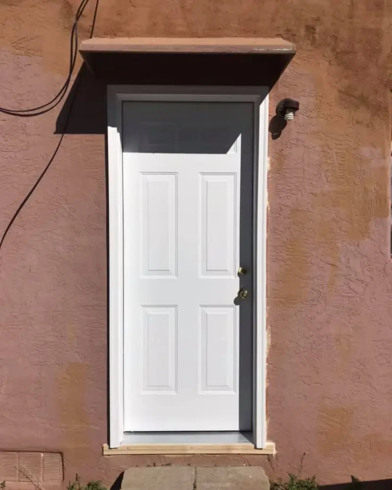 White six-panel exterior door under an awning