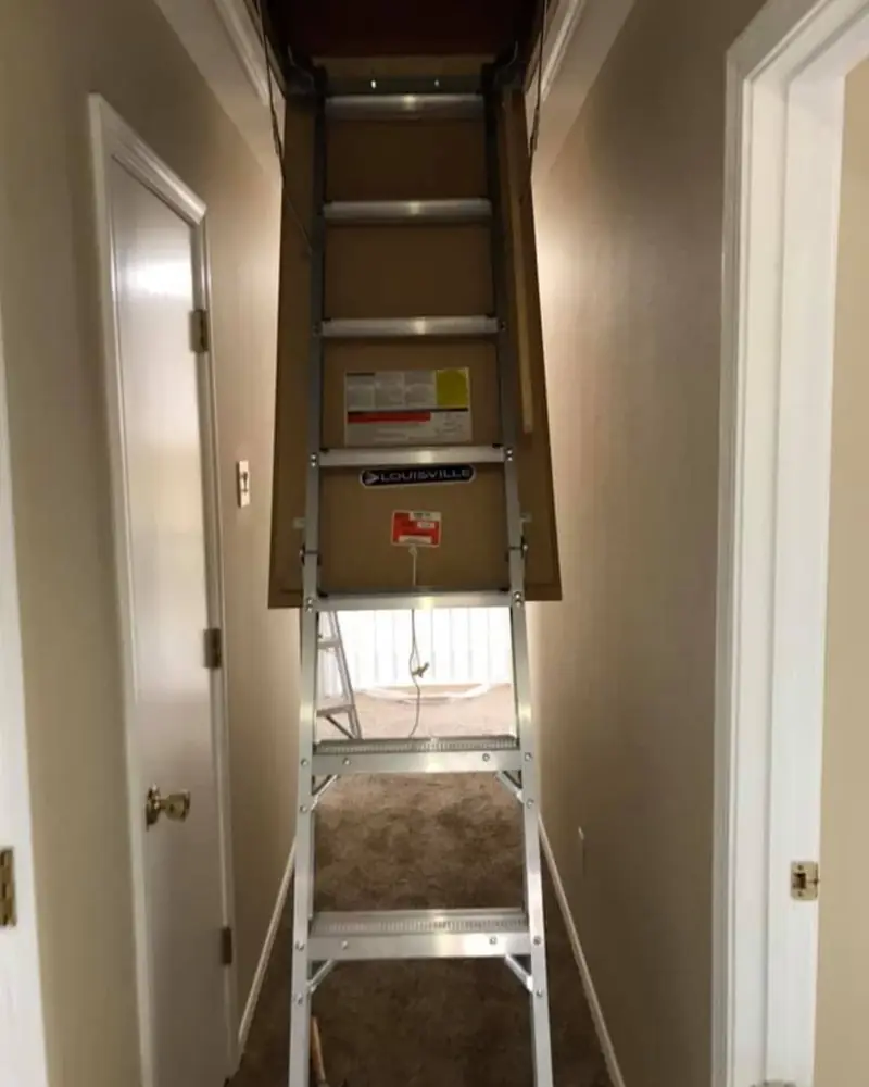 Drop-down attic ladder in a hallway ceiling